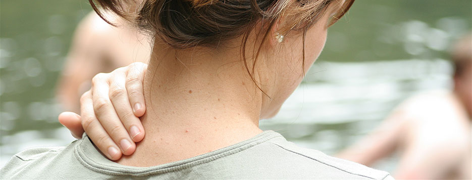 Woman holding her neck, indicating chronic pain.