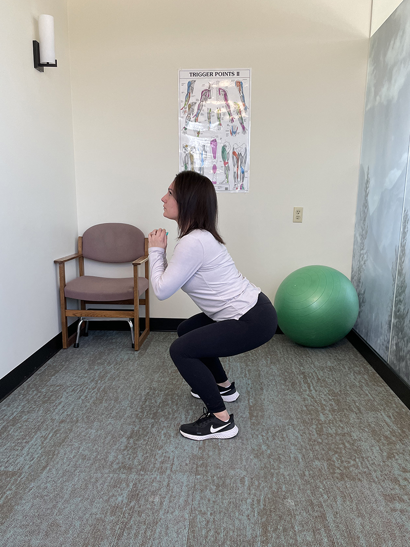 Woman doing a squat in a physiotherapy clinic.
