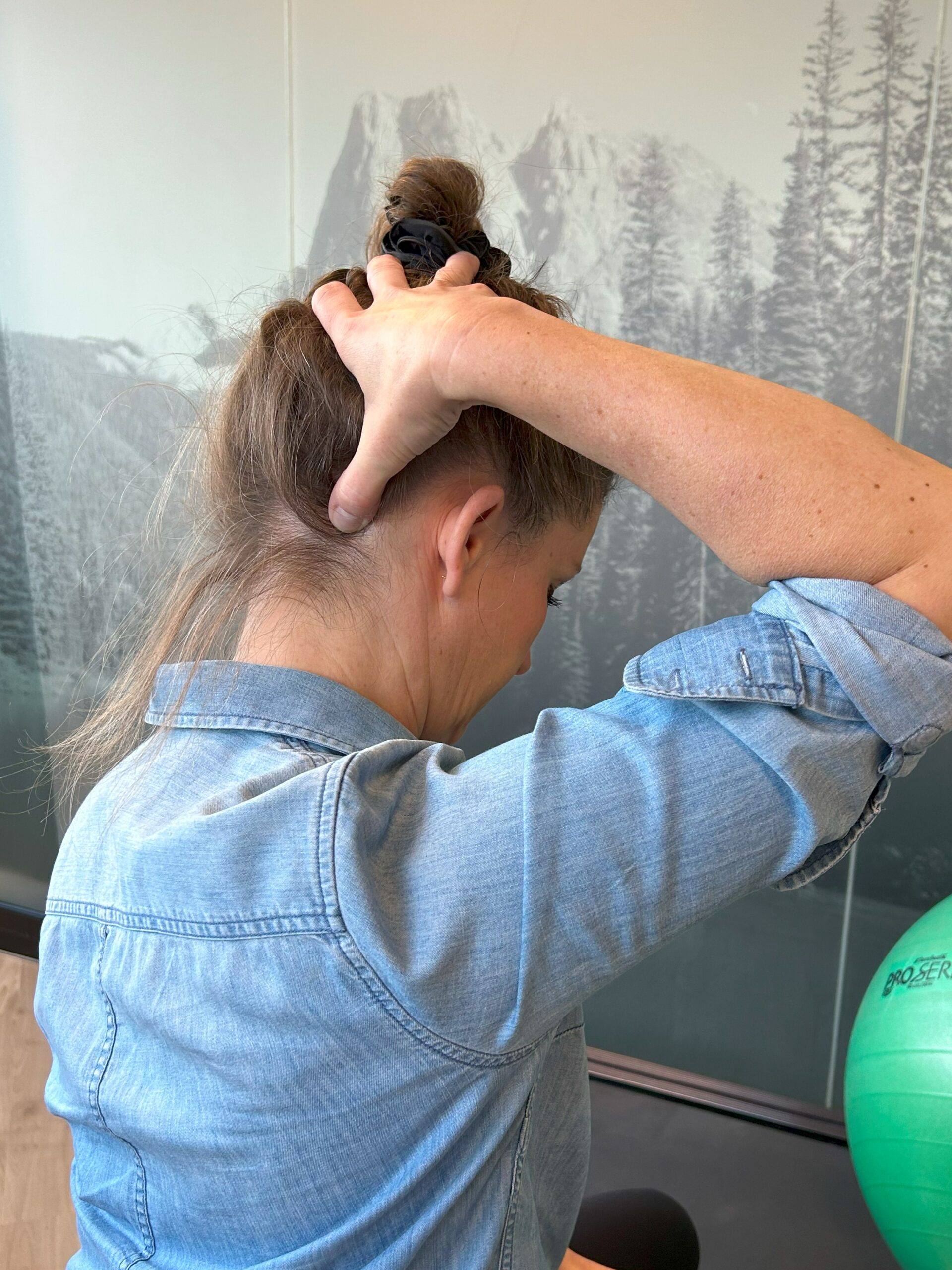 A lady demonstrating how to trigger a muscle release in the neck.