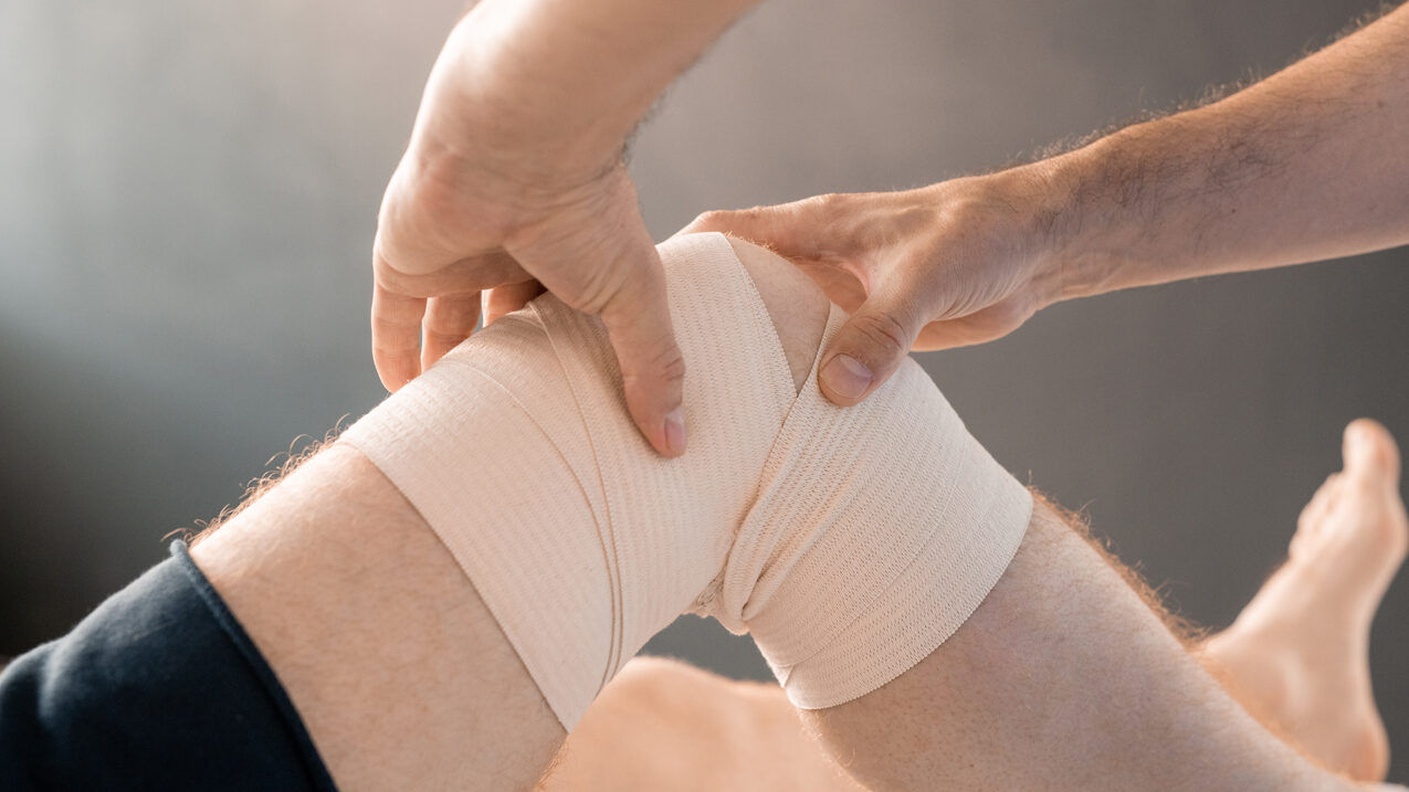 hands massaging a sport knee injury