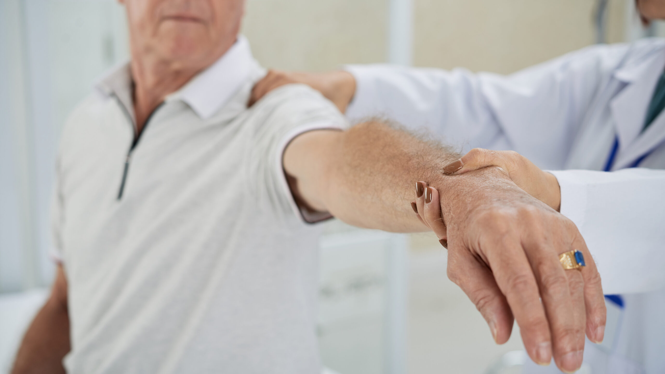 Cropped image of doctor examining patients arm after rehabilitation